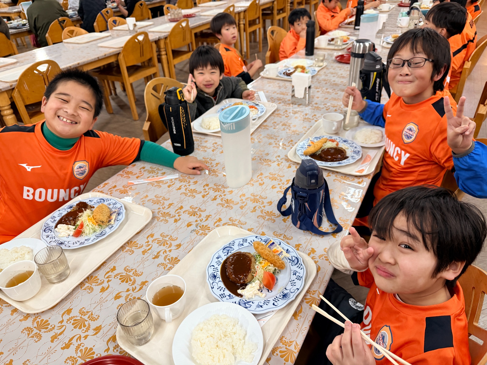 合宿で仲間と食事を楽しむ子どもたち